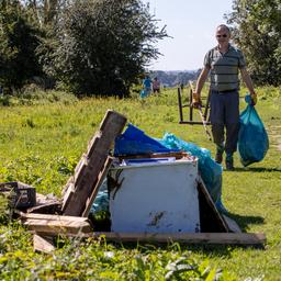 Duizenden vrijwilligers ruimen aangespoeld afval rond de Maas op