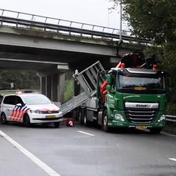 Video | Vrachtwagen ramt viaduct en botst tegen politiewagens