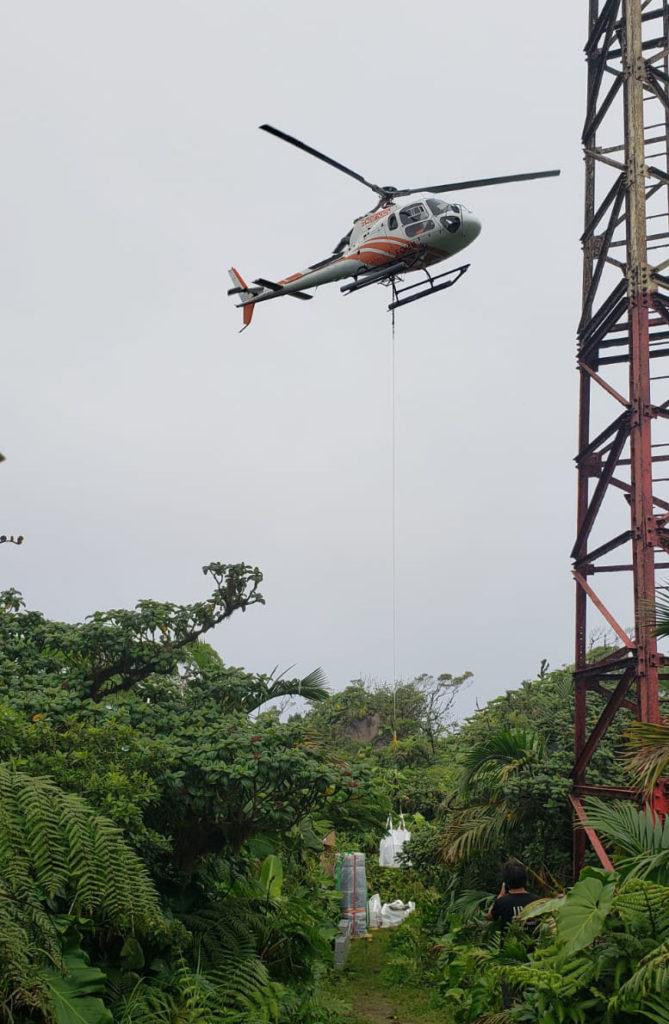Helikopter tilt grote lading oude batterijen van Mount Scenery