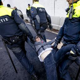 Politie probeert honderden klimaatactivisten met slijptollen en cola van A12 te verwijderen