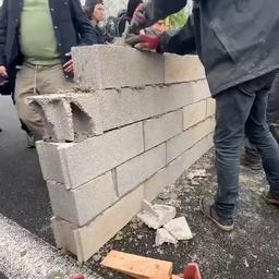 Video | Fransen metselen muurtje om snelweg te blokkeren